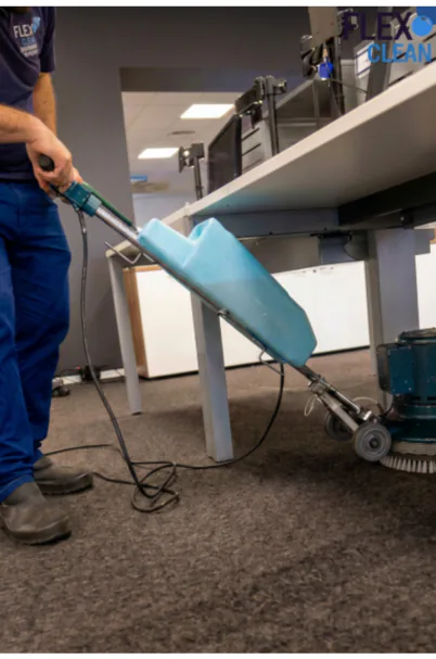 Técnico da Flex Clean realizando serviço profissional em carpete de escritório