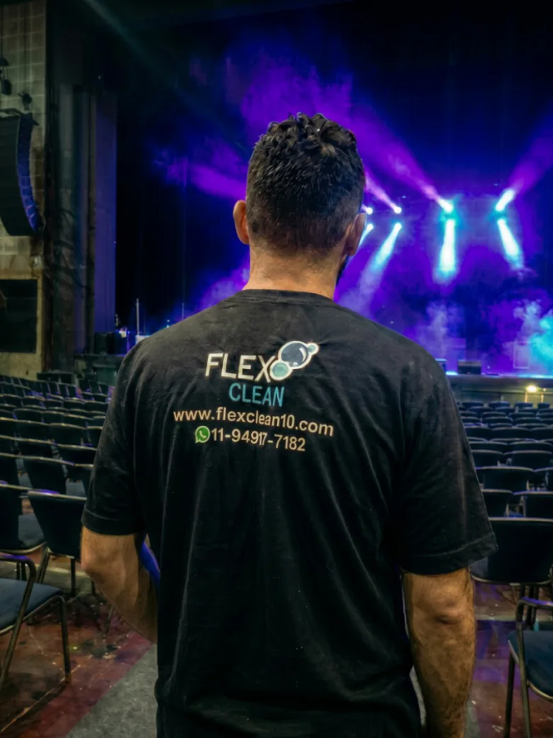 Profissional da Flex Clean em ambiente de teatro e eventos com palco ao fundo