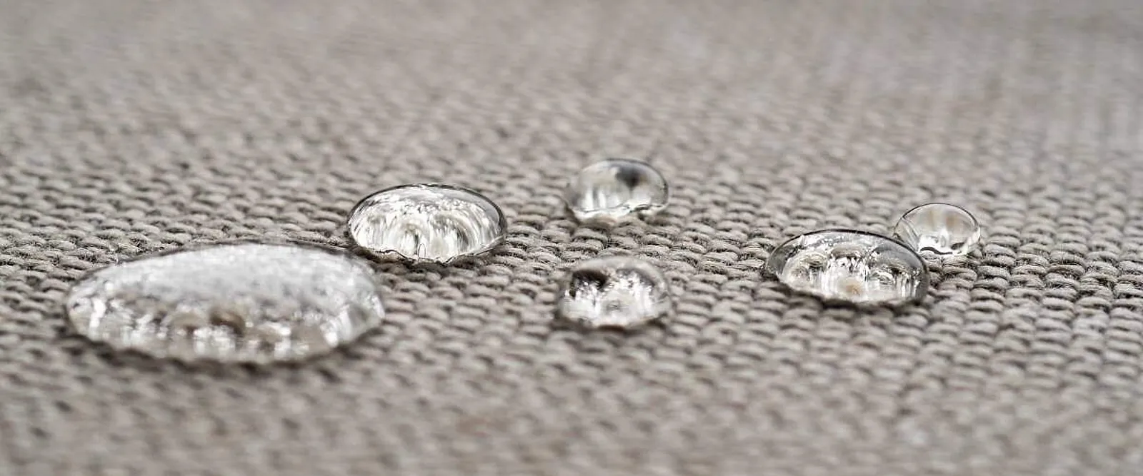 Gotas de água paradas sobre o tecido de um estofado impermeabilizado, sem penetrar na trama