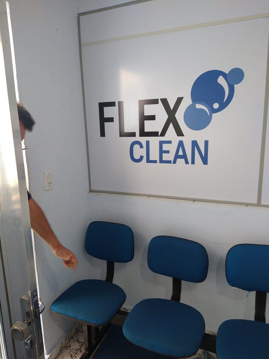Recepção com cadeiras estofadas enfileiradas junto à parede