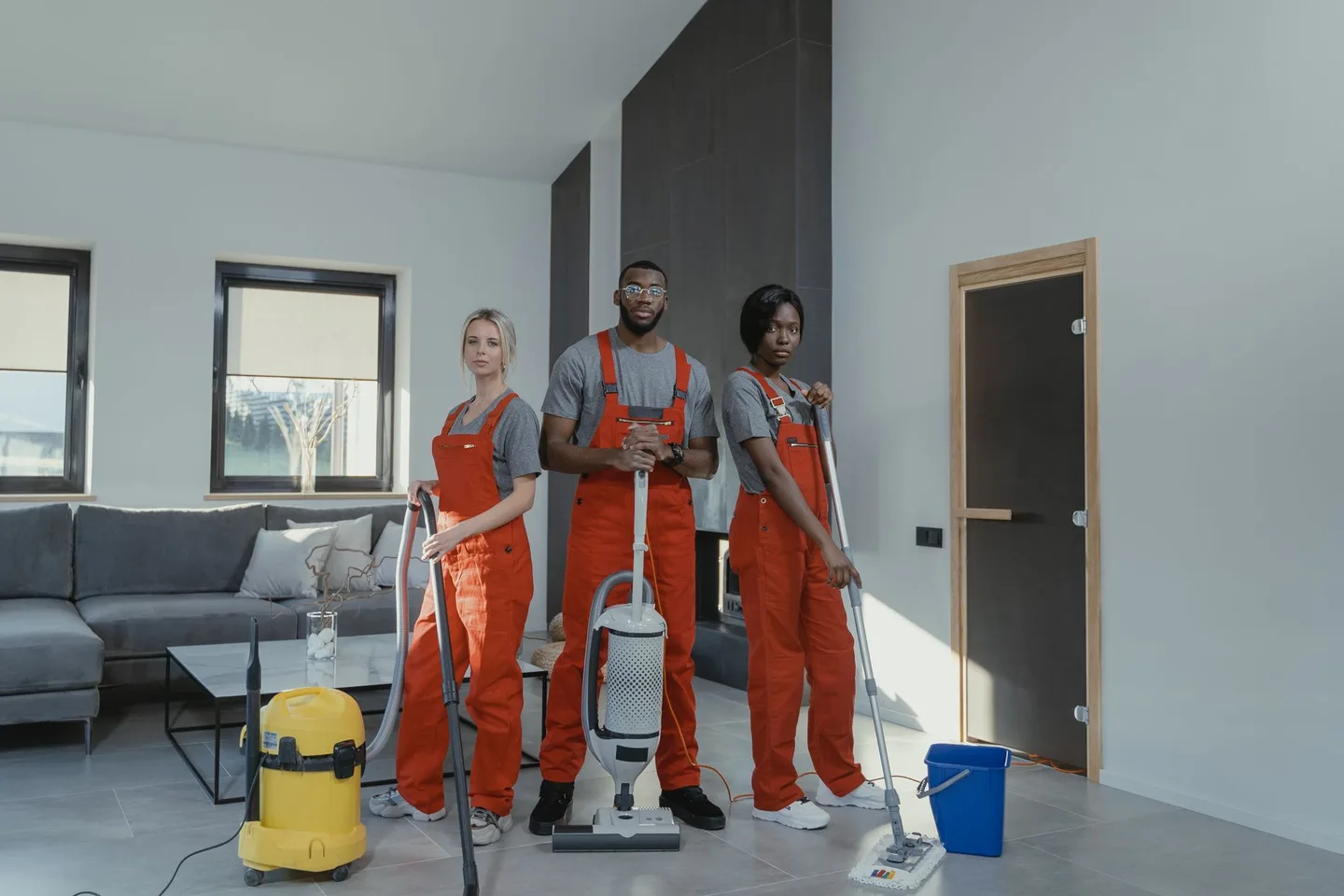 Equipe uniformizada de limpeza com equipamento profissional em um ambiente entregue