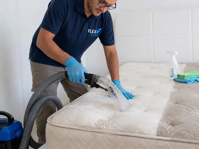 Profissional da Flex Clean higienizando colchão com extratora e luvas de proteção
