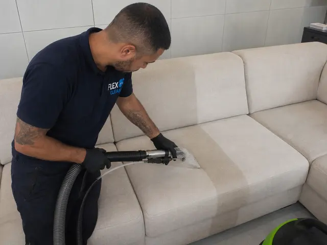 Técnico da Flex Clean higienizando o assento de um sofá claro com extratora